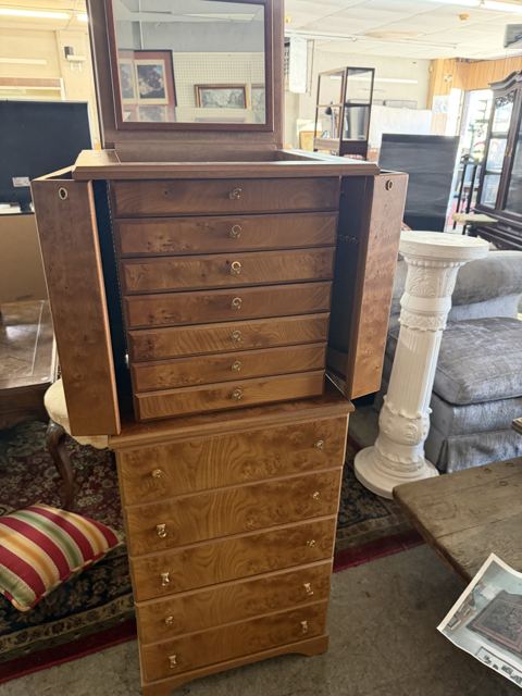 Burl wood jewelry armoire with mirrored lid on a matching chest of drawers