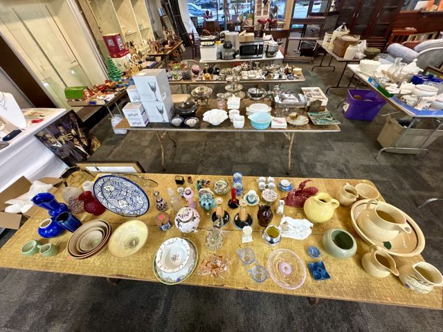 Table of cobalt glass, pottery pitchers and a painted platter