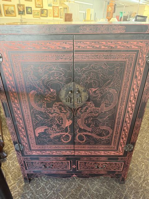 Black and red lacquered cabinet with painted dragons and brass hardware