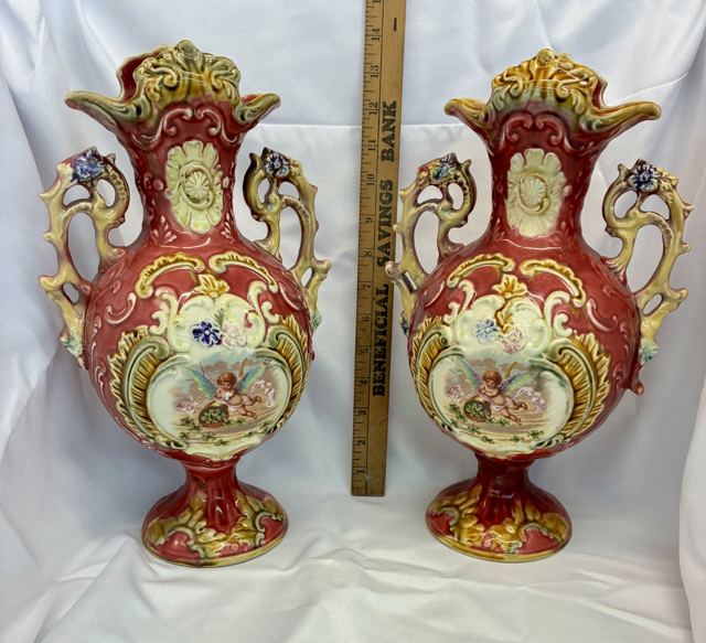 Pair of majolica mantel vases with cherub panels and ornate handles