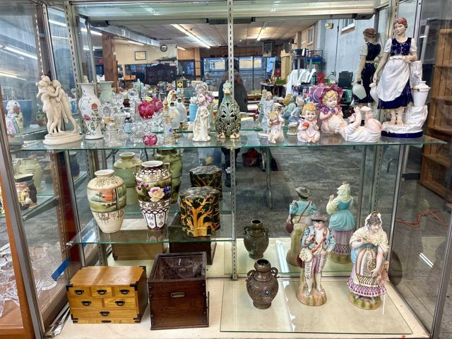 Display case of porcelain figurines, vases and boxes