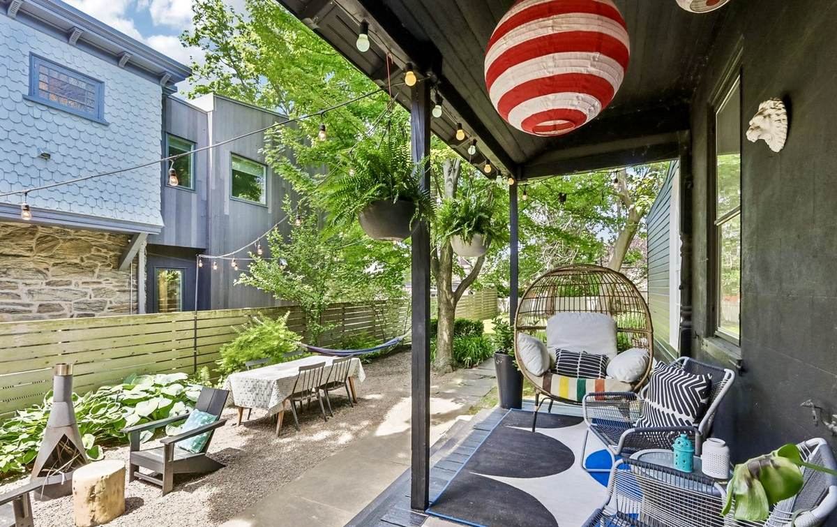Back porch with hanging egg chair and string lights
