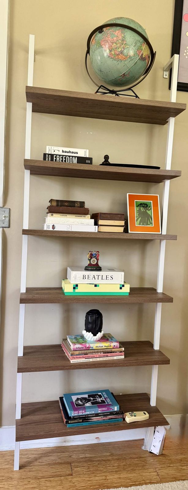 Ladder bookshelf with Beatles books and globe